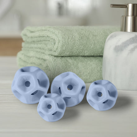 Green towels, a white soap dispenser, and purple silicone Soma Flex®  sizing seton a light surface.