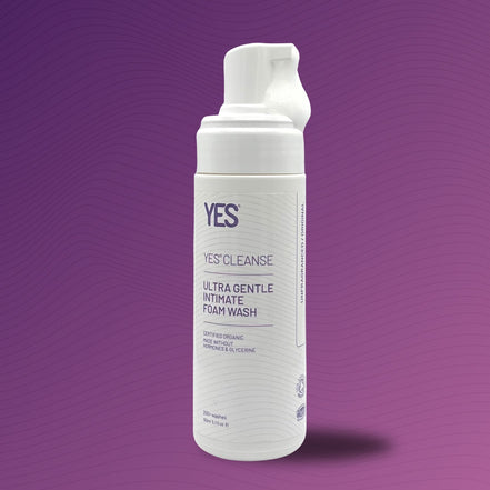 White bottle of YES Cleanse Ultra Gentle Intimate Foam Wash on a purple background