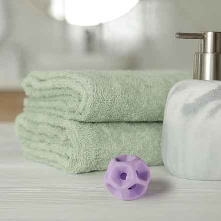 Green towels, a white soap dispenser, and purple silicone Soma Flex® 35  on a light surface.