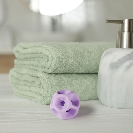 Green towels, a white soap dispenser, and purple silicone Soma Flex® 40 on a light surface.