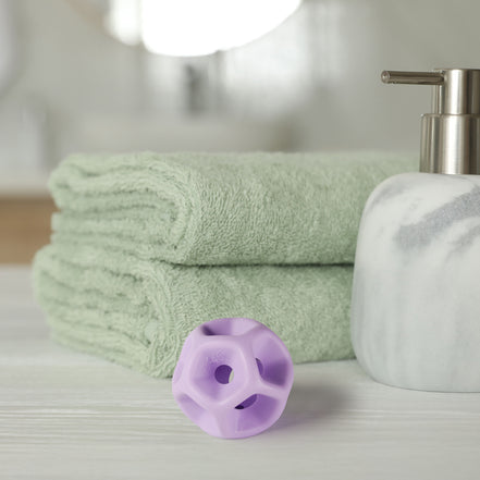 Green towels, a white soap dispenser, and purple silicone Soma Flex® 45  on a light surface.